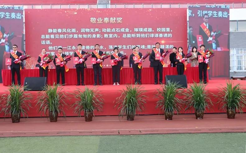 主席台上的各位领导为获得“敬业奉献奖”“卓越耕耘奖”“校长提名奖”“优秀管理奖”“教育功勋奖”的教师和获得“优秀学子奖”的学生代表颁发获奖证书.webp.jpg